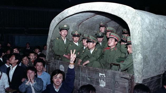 Residents of Beijing surround an army convoy of 4,000 soldiers May 20, 1989. The tone increasingly combative, the leadership decided upon martial law on May 20. Party chief Zhao Ziyang visited students on May 19, accompanied by the hardline Li Peng and future premier Wen Jiabao. Zhao told the students, “We have come too late”. It was the last time Zhao was seen in public. He was later purged. (Ed Nachtrieb / REUTERS File)