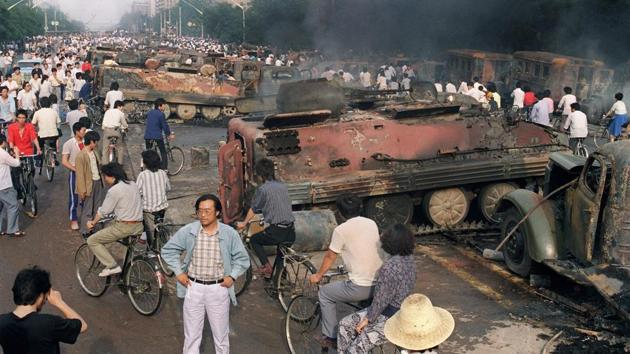 Residents near the smoking remains of armoured personnel carriers during clashes on June 4, 1989. Li’s move towards martial law has seen him reviled by many to this day as the “Butcher of Beijing”. Some 100,000 people marched demanding Li’s removal on May 23. A government-sponsored counter-demonstration called students “traitorous bandits” on May 31. (Manny Ceneta / AFP)