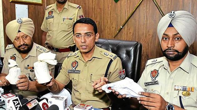 Police officials showing the recovered hand grenades and mobile phone at a press conference in Amritsar on Monday, June 3, 2019.(HT Photo)