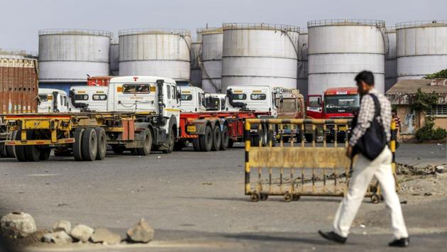 Trucks sit parked next to oil tanks near the Jawaharlal Nehru Port. Among the industries most at risk would be agriculture, auto parts and pharmaceuticals, Surjewala said. “We urge Prime Minister Narendra Modi to make a comprehensive statement on the issue to the nation and place before the public a way forward to overcome this grave trade and economic crisis,” Surjewala told reporters in New Delhi. (Dhiraj Singh / Bloomberg)