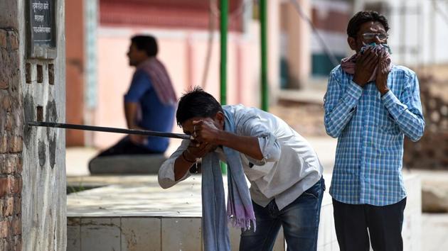 A man drinks water from a roadside tap during a hot day in Churu, Rajasthan on June 4, 2019. Several places in the state are reeling under ‘severe heatwave’ conditions since the last one week.(AFP)