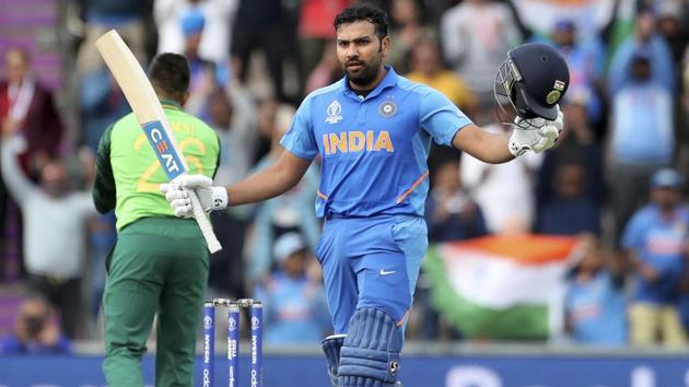 India's Rohit Sharma raises his bat and helmet to celebrate scoring a century. (AP)