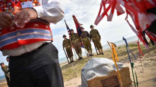 US soldiers dressed in WWII US military uniforms stand guard during a ceremony on Omaha Beach in Saint-Laurent-sur-Mer, western France on June 5, 2019, in homage to Native Americans who took part in the D-Day landings of World War II. The second day of ceremonies moved to France after spirited commemorations in Portsmouth, England, the main embarkation point for the transport boats. (Loic Venance / AFP)
