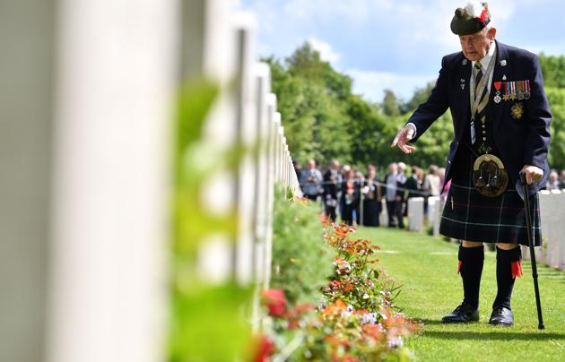 Scottish war veteran John Lamont looks at the graves of fallen British soldiers during a Service of Remembrance at the Commonwealth War Graves Cemetery in Bayeux, Normandy, on June 6, 2019. There were victims on all sides. A total of 4,414 Allied troops were killed on D-Day. More than 5,000 were injured. In the ensuing Battle of Normandy, 73,000 Allied forces were killed and 153,000 wounded. (Ben Stansall / AFP)