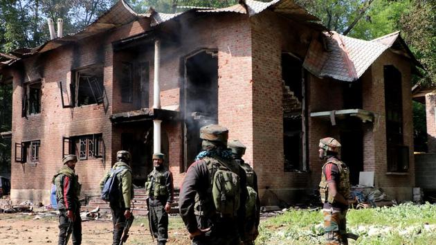 Army jawans stand guard outside a damaged house after a gun battle between militants and security forces at Panjran Pulwama district of south Kashmir on Friday. Four militants were killed in an encounter with security forces.(ANI photo)