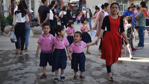 Children walk through a carpark where the Heyitkah mosque once stood in Hotan, Xinjiang. Satellite images reviewed by AFP and visual analysis by the non-profit Earthrise Alliance show that 36 mosques and religious sites have been torn down or had their domes and corner spires removed since 2017. (Greg Baker / AFP) Children walk through a carpark where the Heyitkah mosque once stood in Hotan, Xinjiang. Satellite images reviewed by AFP and visual analysis by the non-profit Earthrise Alliance show that 36 mosques and religious sites have been torn down or had their domes and corner spires removed since 2017. (Greg Baker / AFP)