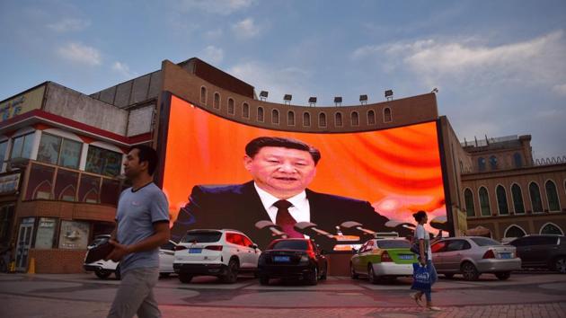 People walk past a screen showing images of Chinese President Xi Jinping in Kashgar. The ruling Communist Party “sees religion as this existential threat,” said James Leibold, an expert on ethnic relations and policy in China at La Trobe University. Over the long term, the Chinese government wants to achieve “the secularisation of Chinese society,” he added. (Greg Baker / AFP) People walk past a screen showing images of Chinese President Xi Jinping in Kashgar. The ruling Communist Party “sees religion as this existential threat,” said James Leibold, an expert on ethnic relations and policy in China at La Trobe University. Over the long term, the Chinese government wants to achieve “the secularisation of Chinese society,” he added. (Greg Baker / AFP)