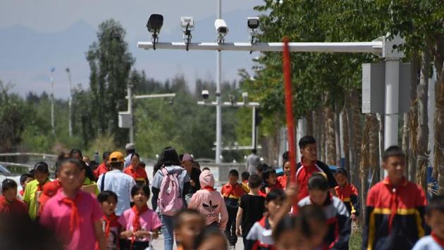 Schoolchildren walk below surveillance cameras in Akto, south of Kashgar. Authorities have thrown a high-tech security net across the region, installing cameras, mobile police stations and checkpoints in seemingly every street in response to a spate of deadly attacks blamed on Islamic extremists and separatists in recent years. (Greg Baker / AFP) Schoolchildren walk below surveillance cameras in Akto, south of Kashgar. Authorities have thrown a high-tech security net across the region, installing cameras, mobile police stations and checkpoints in seemingly every street in response to a spate of deadly attacks blamed on Islamic extremists and separatists in recent years. (Greg Baker / AFP)