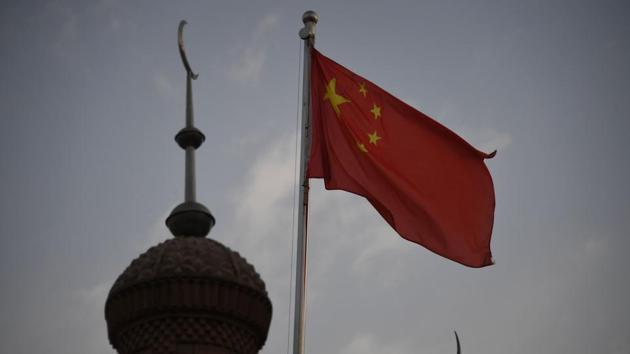 The Chinese flag flies over the Juma mosque in the restored old city of Kashgar. Propaganda signs with slogans such as “love the Party, love the country” hang at many mosques. In Yengisar county, south of Kashgar, one mosque hung a photo of Xi Jinping inside its premises, where most posters were dedicated to warning against religious extremism and promoting ethnic harmony. (Greg Baker / AFP) The Chinese flag flies over the Juma mosque in the restored old city of Kashgar. Propaganda signs with slogans such as “love the Party, love the country” hang at many mosques. In Yengisar county, south of Kashgar, one mosque hung a photo of Xi Jinping inside its premises, where most posters were dedicated to warning against religious extremism and promoting ethnic harmony. (Greg Baker / AFP)