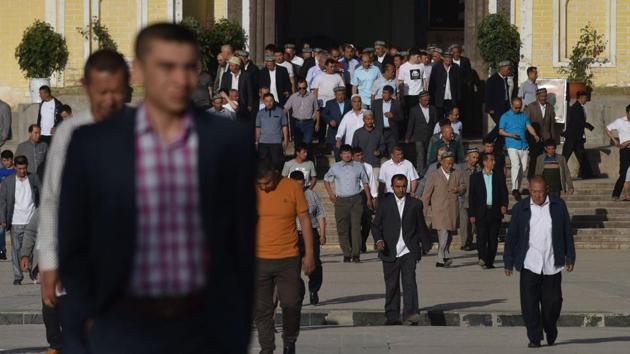Uighur men leave after Eid-ul-Fitr prayers at Idkah Mosque in Kashgar. On Wednesday, locals celebrating Eid quietly filed into the entrance of the state-approved Idkah Mosque -- one of the largest in China -- as police and officials fenced off the wide square surrounding the building and plainclothes men monitored every person’s actions. (Greg Baker / AFP) Uighur men leave after Eid-ul-Fitr prayers at Idkah Mosque in Kashgar. On Wednesday, locals celebrating Eid quietly filed into the entrance of the state-approved Idkah Mosque -- one of the largest in China -- as police and officials fenced off the wide square surrounding the building and plainclothes men monitored every person’s actions. (Greg Baker / AFP)
