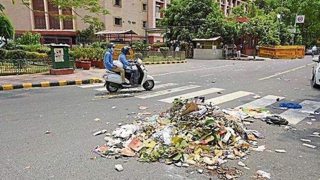 Last year, north body staff had thrown garbage outside Shastri Bhawan, to protest late salary.(HT Archive)