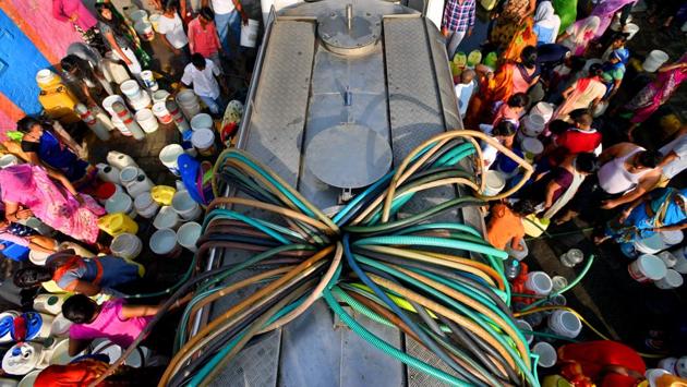 Residents wait with their empty containers to fill drinking water from a municipal tanker, at Chanakyapuri, in New Delhi. (Amal KS / HT Photo)