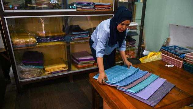 Natcha Swanaphoon, Niphon’s sister seen arranging hand-woven silk fabrics in her shop near Darul Falah. Today, Niphon’s shop has no traditional silk weavers under 60. Thailand exports around $15 million-worth of silk, but Vietnam and China now provide fierce competition to the lucrative US market. (Romeo Gacad / AFP)