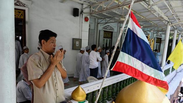 A man attends Friday noon prayers outside the Haroon mosque decorated with a Thai flag. Muslims from Iran, Indonesia and other parts of Asia have long settled in Bangkok and around central Thailand, communities of traders and businessmen drawn to the city’s location at the heart of Southeast Asia. (Romeo Gacad / AFP)