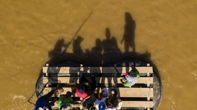 Aerial picture showing migrants and residents using a makeshift raft to cross the Suchiate river from Tecun Uman in Guatemala to Ciudad Hidalgo in Chiapas State, Mexico. (Pedro Pardo / AFP) Aerial picture showing migrants and residents using a makeshift raft to cross the Suchiate river from Tecun Uman in Guatemala to Ciudad Hidalgo in Chiapas State, Mexico. (Pedro Pardo / AFP)