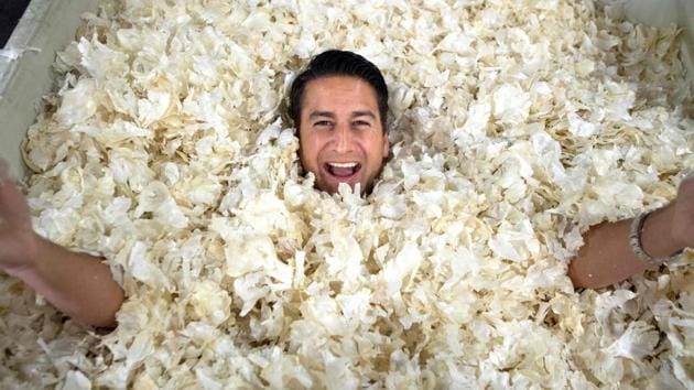 Christopher Ranch Executive Vice President Ken Christopher poses for a photo after burying himself in a crate of garlic skins at Christopher Ranch in Gilroy, California, United States of America. As most US farmers feel the brunt of the trade war with China, some, like garlic and honey producers who have struggled for years, are applauding the new tariffs on Chinese goods. (Josh Edelson / AFP) Christopher Ranch Executive Vice President Ken Christopher poses for a photo after burying himself in a crate of garlic skins at Christopher Ranch in Gilroy, California, United States of America. As most US farmers feel the brunt of the trade war with China, some, like garlic and honey producers who have struggled for years, are applauding the new tariffs on Chinese goods. (Josh Edelson / AFP)
