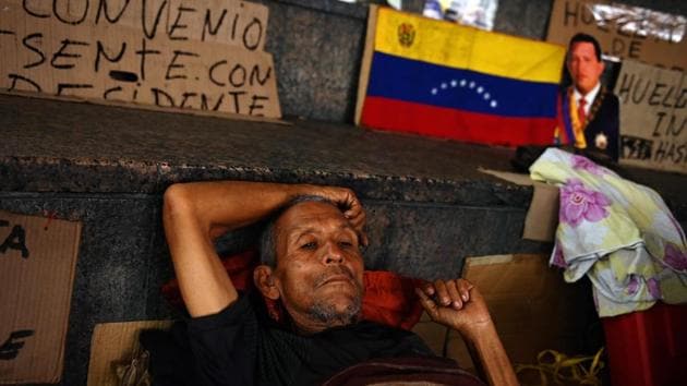One of 23 workers of the oil sector holding a hunger strike since May 30 remains at the Plaza de la Moneda square near the presidential palace to demand the government of President Nicolas Maduro about the payment of labour liabilities, in Santiago, Chile. (Marvin Recinos / AFP) One of 23 workers of the oil sector holding a hunger strike since May 30 remains at the Plaza de la Moneda square near the presidential palace to demand the government of President Nicolas Maduro about the payment of labour liabilities, in Santiago, Chile. (Marvin Recinos / AFP)
