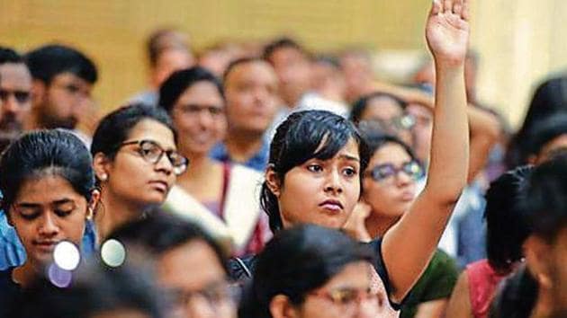 A girl raises her hand to ask a question as students and parents gather during a counselling session with experts on the admission process of Delhi University .(Raj K Raj/ Hindustan Times)