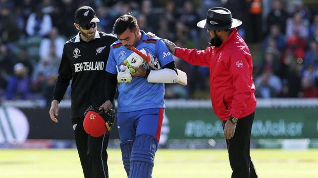 New Zealand's Kane Williamson, left and Umpire Aleem Dar check that Afghanistan's Rashid Khan is ok, after a ball bowled by Lockie Ferguson bounced off Rashid's helmet and onto the stump during the ICC Cricket World Cup(AP) New Zealand's Kane Williamson, left and Umpire Aleem Dar check that Afghanistan's Rashid Khan is ok, after a ball bowled by Lockie Ferguson bounced off Rashid's helmet and onto the stump during the ICC Cricket World Cup(AP)