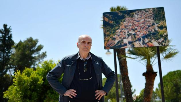Secretary of the Lega Nord for the Riace marina area, Claudio Falchi poses by a billboard of Riace. He moved here 25 years ago, “Here, we need order and discipline; it’s not racism, it’s just that this is our home. We welcome them and then they make problems”. Until a few years ago, the Lega was a separatist party at the other end of the country which sneeringly referred to southerners as “bumpkins” or worse. (Alberto Pizzoli / AFP) 