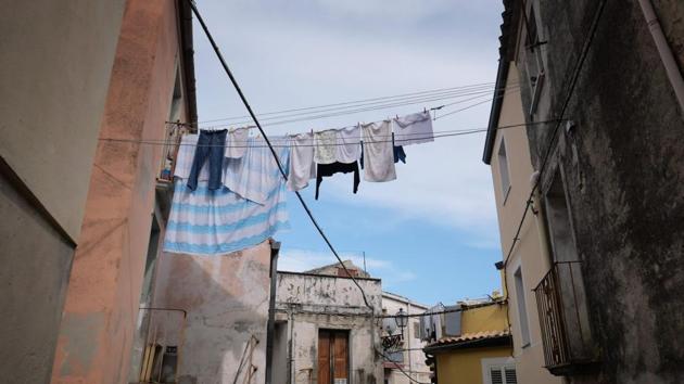 Laundry hangs to dry across a street. The shops and workshops previously occupied by migrants are now shuttered. The village’s historic streets are largely deserted, with funereal music occasionally punctuating the silence. On the southern island of Lampedusa, where many migrants arrived after making the perilous journey across the Mediterranean, the Lega won more than 45% of votes. (Alberto Pizzoli / AFP) 