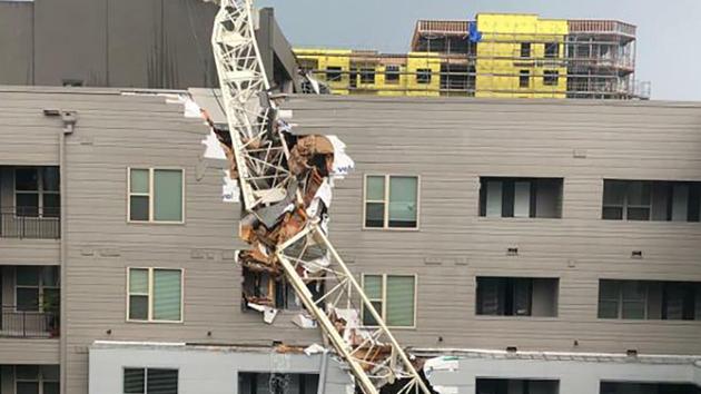 The crane fell onto the Elan City Lights apartment complex, which left a large hole in the east side of the building and landed on an adjacent parking garage.(AP Photo)