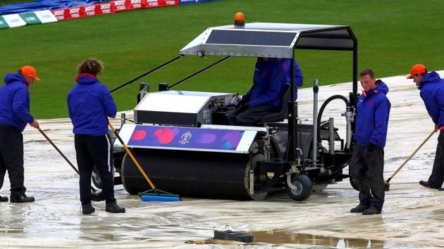 Ground-keepers brush water from the covers as rain delays the start of play ahead of the ICC World Cup 2019. (AFP) Ground-keepers brush water from the covers as rain delays the start of play ahead of the ICC World Cup 2019. (AFP)