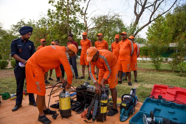 Personnel from National Disaster Response Force (NDRF) check emergency and rescue material at a NDRF camp in Chiloda, Ahmedabad. A heavy rainfall warning has been issued in parts of Gujarat in the next few days due to a depression in the Arabian Sea which is likely to turn into a severe cyclonic storm. Fishermen have been advised not to venture into the sea in the next few days and ports have been asked to flag the danger signal, India Meteorological Department official said. (Sam Panthaky / AFP)