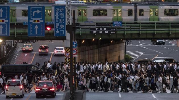 A Yamanote Line train travels above commuters walking across the crossing during evening rush hours in the Shinjuku district of Tokyo. For most Tokyoites, the line is an incredibly punctual and efficient transportation system for commuting. For tourists, it offers a glimpse into the lives of ordinary people in many of the city’s neighborhoods. (Jae C. Hong / AP)