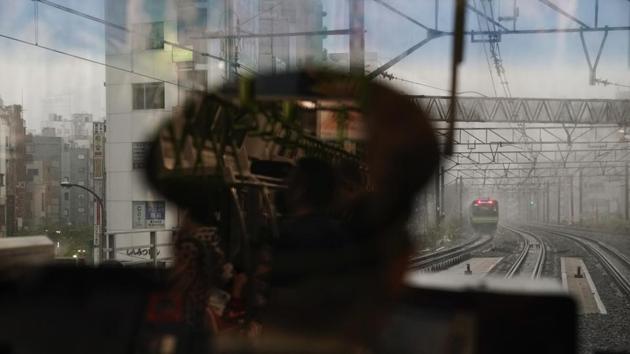 A Yamanote Line train conductor sits in a control room as another Yamanote Line train approaches Ebisu Station in Tokyo. Running above ground, the train offers clear views from its wide windows as it moves 3 million to 4 million people a day — about the same as the entire population of the U.S. state of Connecticut. (Jae C. Hong / AP)