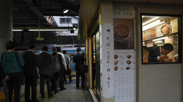 A man eats his breakfast in a noodle shop located on a platform. Eating on the train is not recommended. For a much better option, commuters get off for an authentic bowl of soba or udon, all priced under 500 yen ($5). (Jae C. Hong / AP)