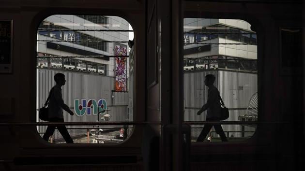 A commuter is reflected in the window of a Yamanote Line train as he gets off at Shimbashi Station in Tokyo. A complete loop of the journey in these trains for about an hour offers scenes of Japanese daily life: jam-packed commutes, views of the famous Shibuya crossing, local shopping arcades and stand-up noodle shops on train platforms. (Jae C. Hong / AP)