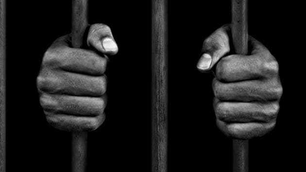 hands of a prisoner on prison bars(Getty Images)