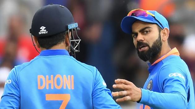 India's captain Virat Kohli (R) speaks with teammate Mahendra Singh Dhoni.(AFP)