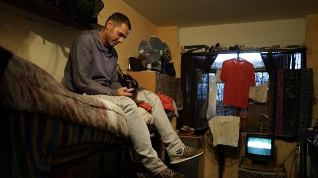 Inmate Rolando Bustamante uses his mobile phone inside his cell at the Punta de Rieles prison. Bustamante is on the last two years of a 21-year sentence for assault and runs a cement block factory inside the prison. The workers, too, are inmates and the product will be sold beyond the walls, with part of the profits going to a sort of bank run by the prisoners themselves. (Matilde Campodonico / AP)