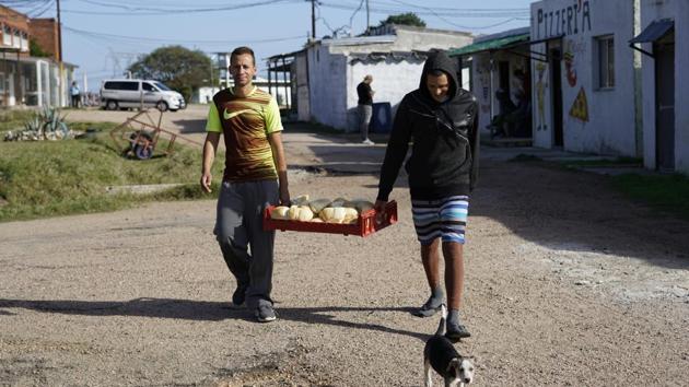 Inmates carry bread to their cells at the Punta de Rieles prison. The bakery is run by former inmates that come back to the prison almost daily and sometimes even sleep there, voluntarily this time. A bakery started by two prisoners have kept it going despite being released and now employ 50 to 70 people. (Matilde Campodonico / AP)
