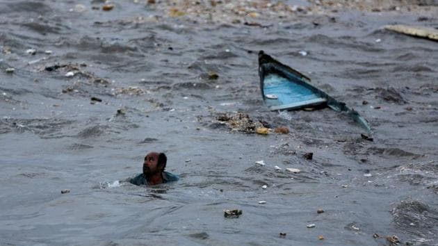 A fisherman swims ashore after his boat capsized due to high waves ahead of the expected landfall of Cyclone Vayu. According to the Meteorological Department, Vayu won’t make a landfall in Gujarat but only skirt through the coast after it changed trajectory overnight. But its effects will be strong with heavy wind and rainfall. (Amit Dave / REUTERS) A fisherman swims ashore after his boat capsized due to high waves ahead of the expected landfall of Cyclone Vayu. According to the Meteorological Department, Vayu won’t make a landfall in Gujarat but only skirt through the coast after it changed trajectory overnight. But its effects will be strong with heavy wind and rainfall. (Amit Dave / REUTERS)