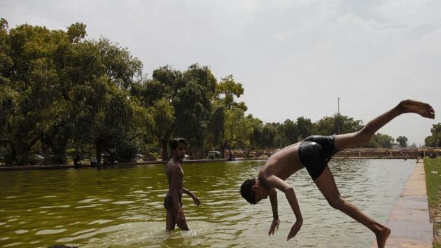 Children take a dip in a pond to get respite from the scorching heat on a hot summer day, at India Gate in New Delhi, Tuesday, June 11, 2019.(PTI photo)