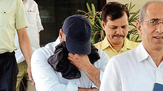 Manpreet Chadha (face covered) with officials of the economic offences wing before being produced in a court. (HT photo) Manpreet Chadha (face covered) with officials of the economic offences wing before being produced in a court. (HT photo)