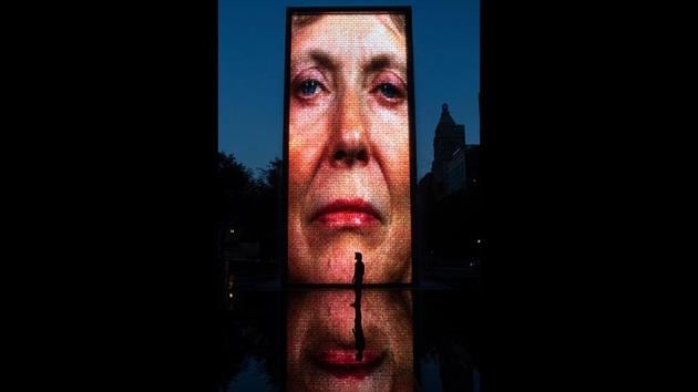 A man stands in front of a monolith video projection at Crown Fountain, in Chicago's Millennium Park. (Amr Alfiky / AP)