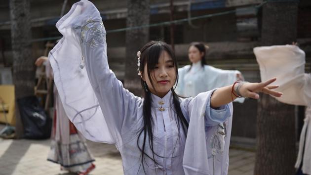 This photo taken on April 5, 2019 shows women wearing "hanfu" - traditional Chinese clothing - rehearsing for a performance at a gathering of hanfu devotees at a park in Beijing. - China has embraced Western fashion and futuristic technology as its economy boomed in recent decades, but a growing group of young people are going back in time, donning traditional "hanfu", or "Han clothing". (Photo by GREG BAKER / AFP) / TO GO WITH AFP STORY CHINA-CLOTHING-TRADITION-HANFU,FEATURE BY QIAN YE AND EVA XIAO(AFP)