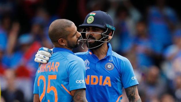 India's Shikhar Dhawan (C) celebrates after scoring a century (100 runs) alongside India's captain Virat Kohli (R) during the 2019 Cricket World Cup group stage match between India and Australia at The Oval in London on June 9, 2019.(AFP)