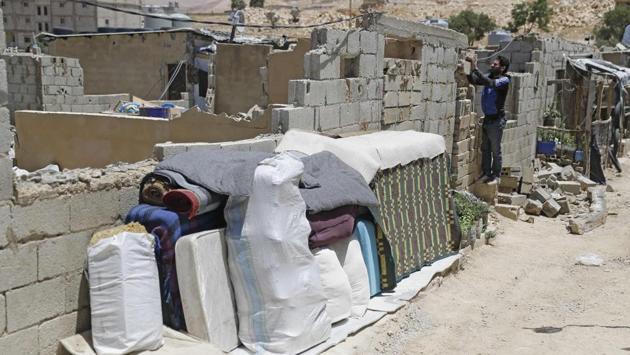 Personal belongings of Syrian refugees seen outside a concrete block shelter at a refugee camp. “Here’s my stable,” said the 35-year-old, Abu Naeem, gesturing to the concrete room and provoking laughter all around. “This is what’s bothering the Lebanese government so much?” he asked. “We’re on the border. This isn’t Beirut or a touristic area,” he said. (Joseph Eid / AFP)