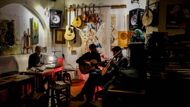 Two men play their guitars during a jam session at the Tejo Bar in Lisbon. “Inspiration for my new record all started here in Lisbon, at Tejo Bar,” Madonna said on Instagram, of her Madame X album, which released yesterday. (Patricia De Melo Moreira / AFP)