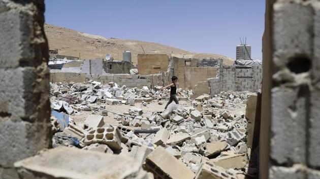 A Syrian boy walks among demolished shelters at a refugee camp. Aid groups have warned the demolition order could make at least 15,000 children homeless. “This situation also adds to the financial burden of refugees, at a time when we know most of them live in poverty,” UNHCR spokeswoman Lisa Abou Khaled said. (Joseph Eid / AFP)