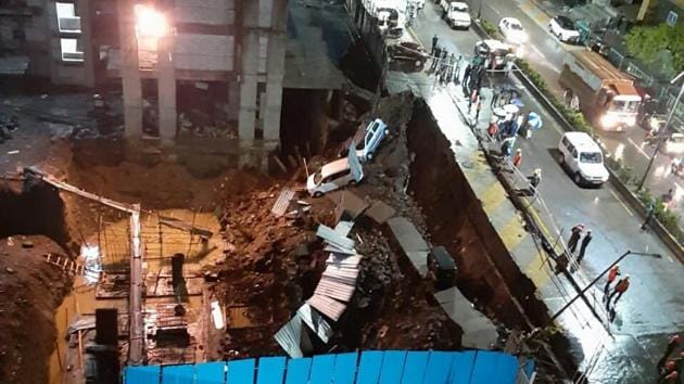 A part of a road in Thane’s Ramachandra Nagar sank late Friday night leading to vehicles parked on the footpath fall in the sink hole.(Praful Gangurde/HT Photo)
