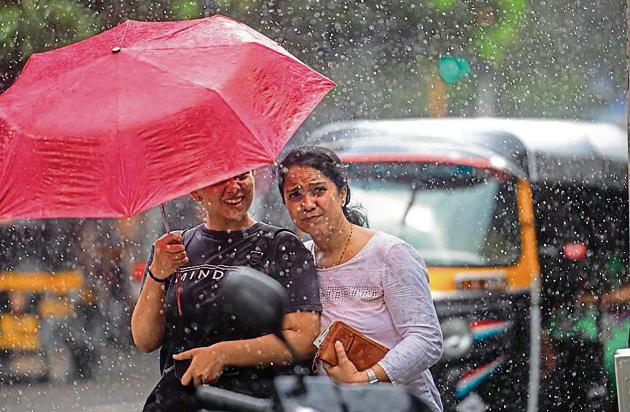 People enjoy rain at Bandra, Hill Road in Mumbai, on Saturday.(HT Photo)