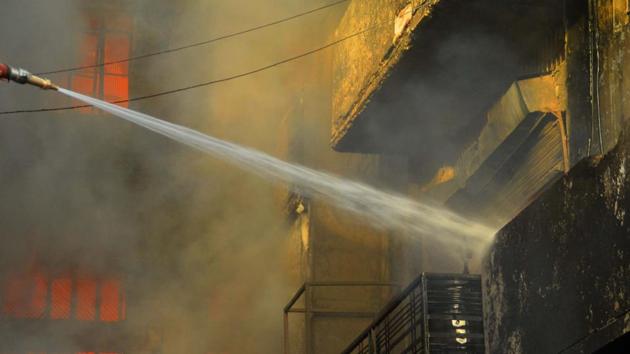 A firefighter tries to douse the fire that broke out at garment factories, at Lajpat Nagar, Noorwala road, in Ludhiana, Punjab. (Gurpreet Singh / HT Photo)