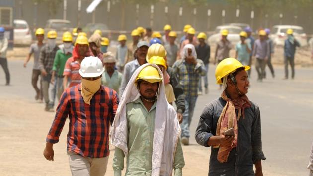 Construction workers walk for miles, sometimes carrying material weighing at least 15 kilogram on their heads, under the unrelenting sun. Many said that they have to rely on a wet piece of cloth to cover their head. Sometimes, even finding drinking water becomes difficult and they have to depend on their employer for it. Many keep falling ill due to exhaustion and fatigue and are forced to skip a day’s work. (Parveen Kumar / HT Photo)