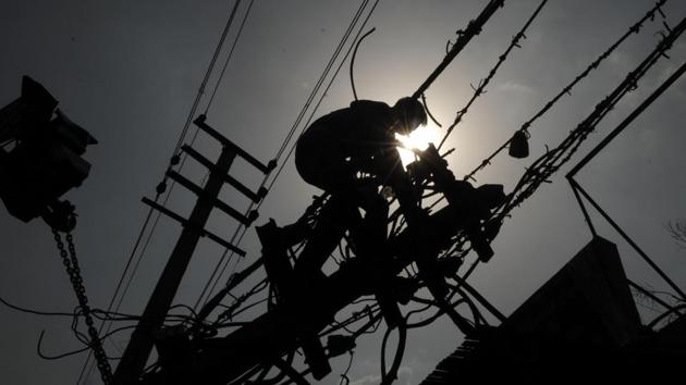 A worker atop a high tension electricity pole, fixing wires in Gurugram, Haryana. The mercury hasn’t dropped below the 40 degrees Celsius mark since June 1, and the consistently high temperatures are unprecedented. (Parveen Kumar / HT Photo)